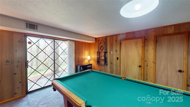 playroom with a textured ceiling, visible vents, carpet floors, wood walls, and billiards