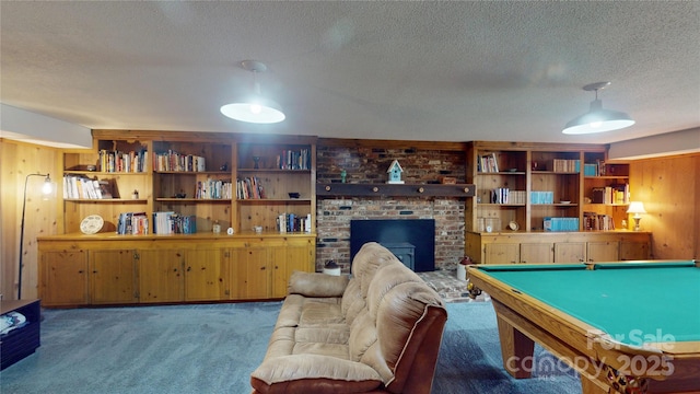 rec room featuring a textured ceiling, wooden walls, and carpet floors