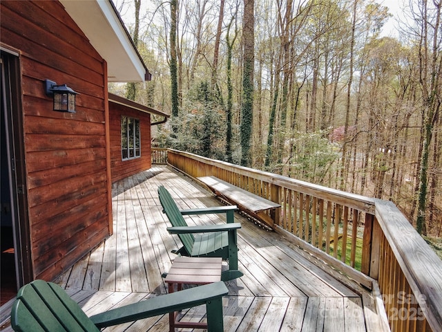 wooden terrace with a wooded view