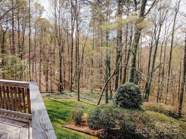 view of yard with a view of trees and a wooden deck