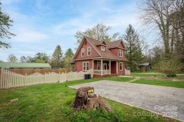 view of front of property with a front yard, a porch, and fence