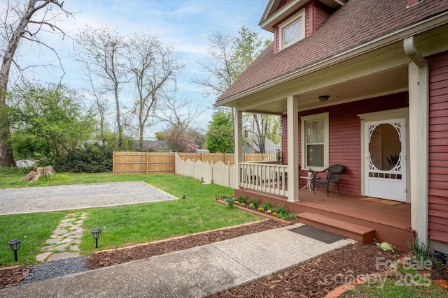 view of yard featuring fence and covered porch