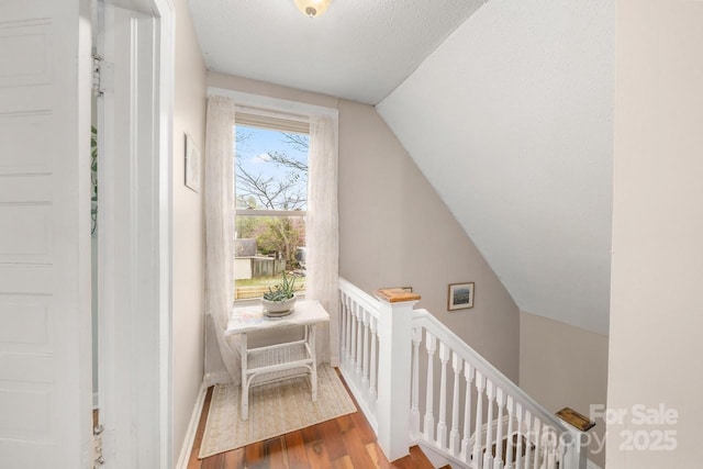additional living space featuring baseboards, vaulted ceiling, and wood finished floors