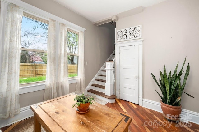 dining area featuring baseboards, stairway, and wood finished floors