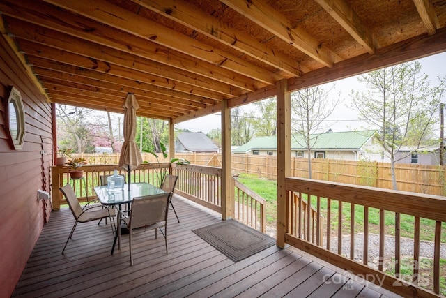 wooden terrace featuring a fenced backyard and outdoor dining area