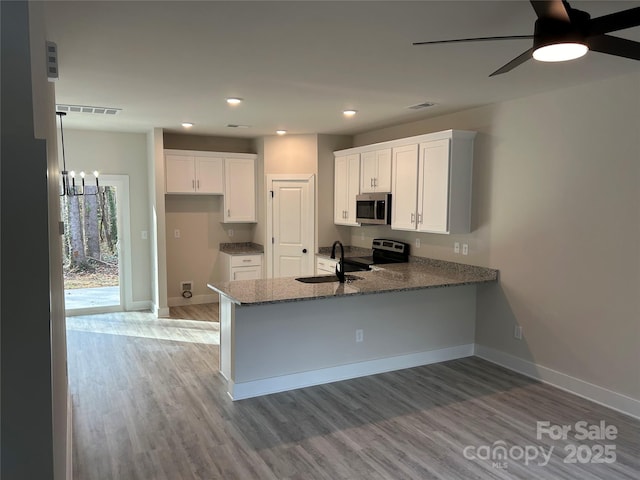 1218 Fall Day Cir SW, Lenoir, NC 28645 - kitchen with dark stone countertops, a sink, a peninsula, appliances with stainless steel finishes, and visible vents