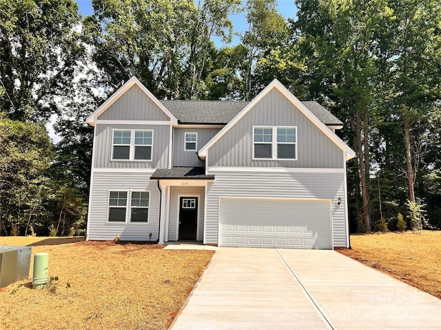 1218 Fall Day Cir SW, Lenoir, NC 28645 - craftsman-style home with a shingled roof, concrete driveway, an attached garage, board and batten siding, and view of wooded area