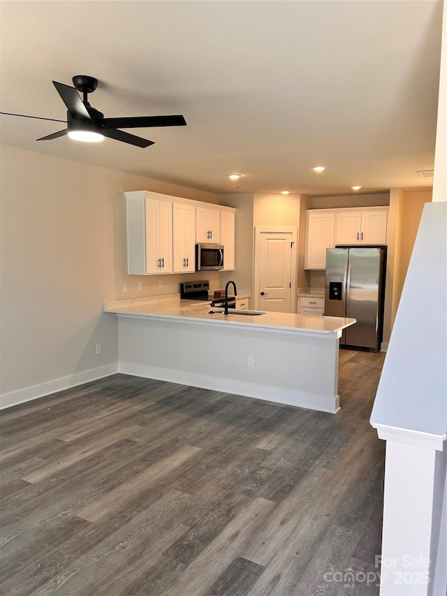 1218 Fall Day Cir SW, Lenoir, NC 28645 - kitchen featuring stainless steel appliances, a peninsula, white cabinetry, dark wood-style floors, and recessed lighting
