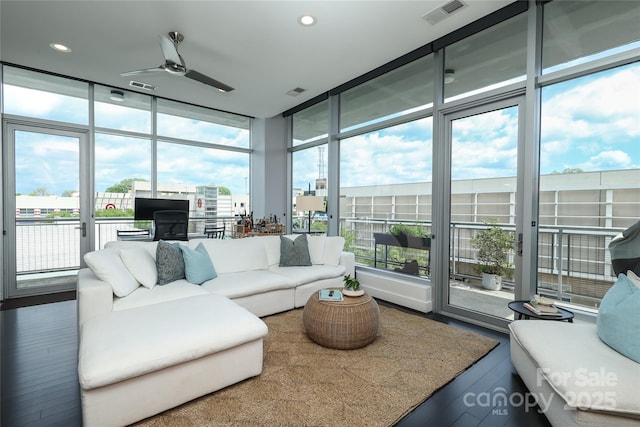 living room with visible vents, ceiling fan, and a wealth of natural light