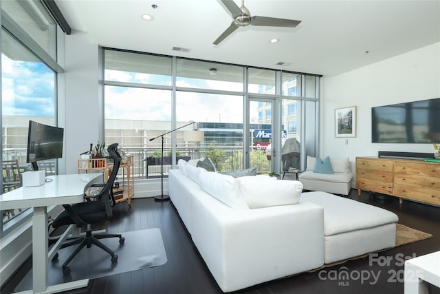 living room featuring dark wood-type flooring, ceiling fan, visible vents, and plenty of natural light
