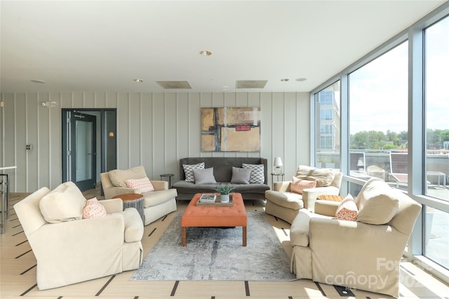 living area featuring wood finished floors, floor to ceiling windows, and visible vents