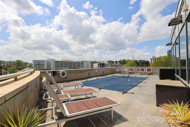 pool with a patio area and a view of city
