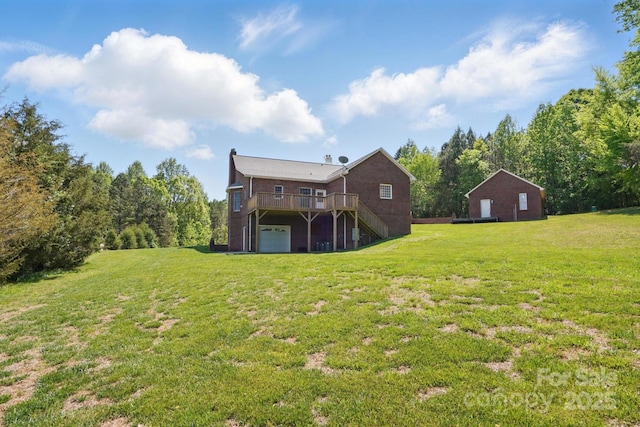 view of yard with an attached garage and a deck