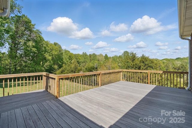 wooden terrace featuring a view of trees