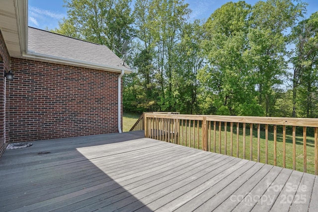 wooden terrace featuring a yard