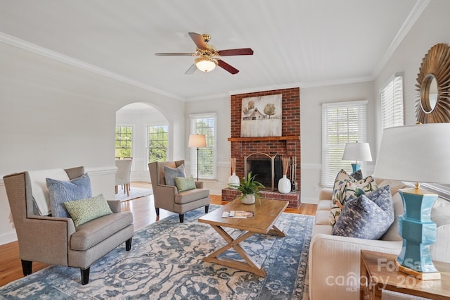 living room with a wealth of natural light, arched walkways, and crown molding
