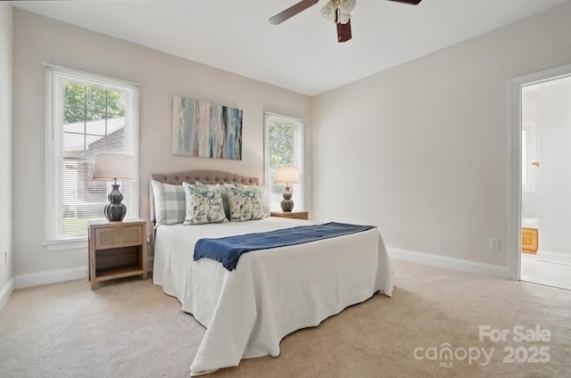 bedroom featuring light carpet, baseboards, and multiple windows