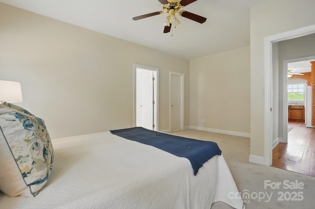 bedroom with baseboards, a ceiling fan, and light colored carpet