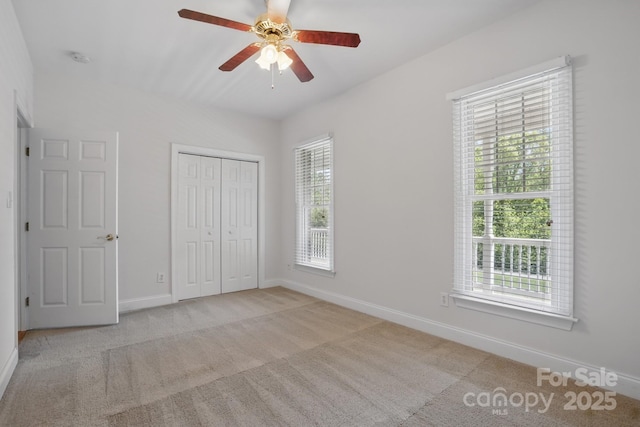 unfurnished bedroom featuring a ceiling fan, baseboards, carpet, and a closet
