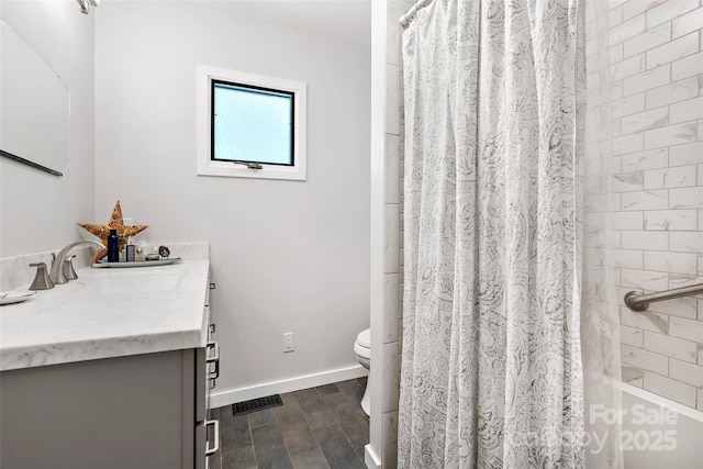 27 Stokes Dr, Asheville, NC 28805 - bathroom featuring toilet, wood finished floors, vanity, baseboards, and shower / bathtub combination with curtain