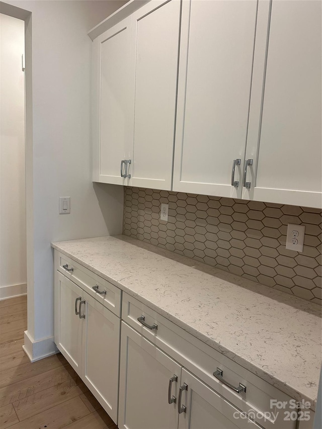 details featuring baseboards, backsplash, and wood finished floors