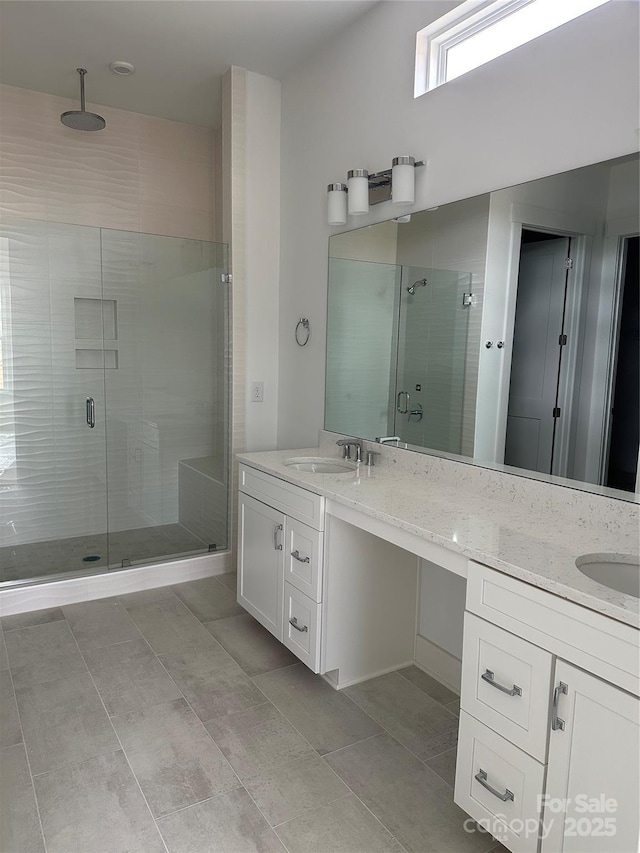 full bath with double vanity, a sink, and a stall shower