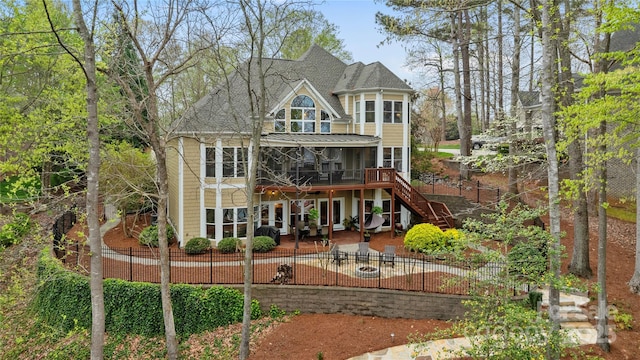 back of property featuring fence, a sunroom, a patio, and stairway