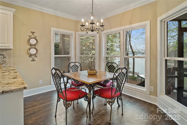 dining area with an inviting chandelier, dark wood-type flooring, baseboards, and crown molding