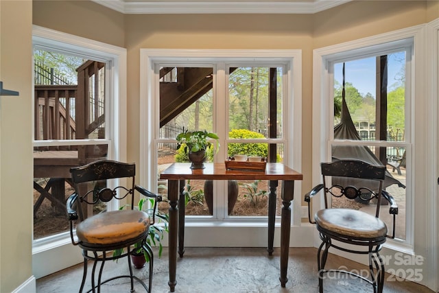 sunroom featuring baseboards and ornamental molding
