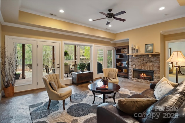 living area with crown molding, recessed lighting, visible vents, a ceiling fan, and a fireplace