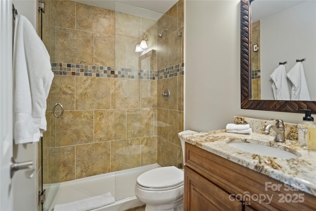 bathroom featuring toilet, vanity, and a tile shower