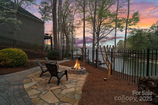 patio terrace at dusk with fence and an outdoor fire pit