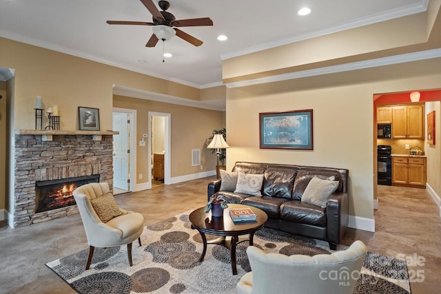 living room featuring crown molding, a ceiling fan, a stone fireplace, baseboards, and visible vents