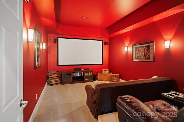 carpeted cinema room featuring a raised ceiling, baseboards, and visible vents