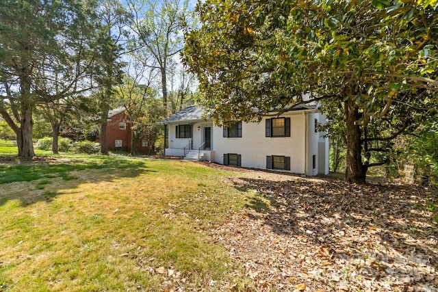 rear view of property featuring a lawn