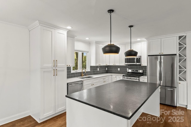 kitchen with stainless steel appliances, dark wood-style floors, a sink, white cabinets, and tasteful backsplash