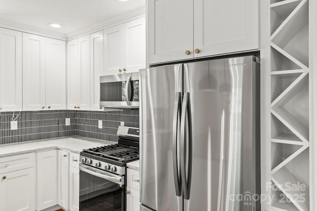 kitchen featuring stainless steel appliances, white cabinets, light stone counters, backsplash, and recessed lighting