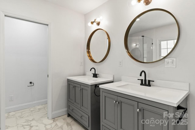 full bath featuring marble look tiles, two vanities, and baseboards