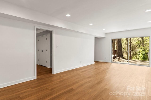 empty room featuring recessed lighting, baseboards, and wood finished floors