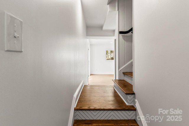 staircase with wood finished floors and baseboards