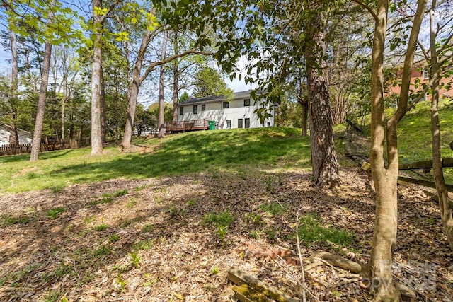 view of green lawn with a wooden deck
