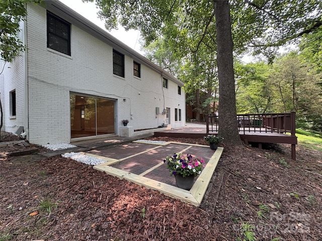 6614 Old Providence Rd, Charlotte, NC 28226 - rear view of house featuring a patio area, brick siding, a wooden deck, and uncovered parking