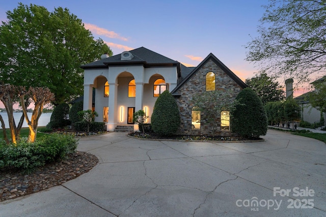 114 Ventana Ct, Mooresville, NC 28117 - view of front facade featuring stucco siding, curved driveway, and stone siding