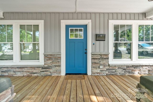 view of exterior entry featuring board and batten siding and stone siding