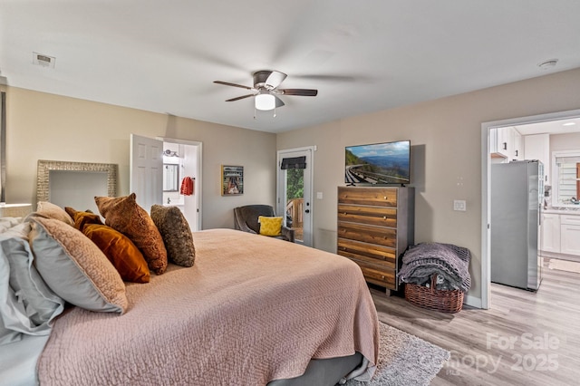 bedroom featuring multiple windows, light wood-style flooring, visible vents, and freestanding refrigerator