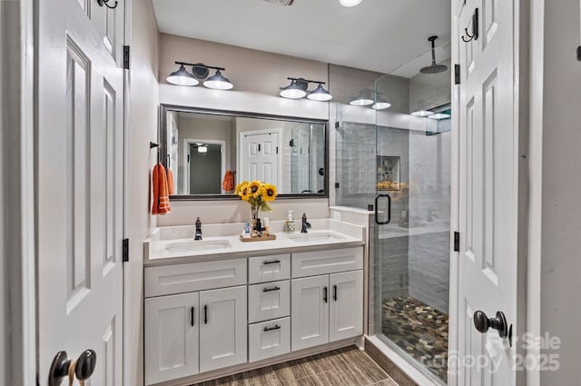 full bathroom with a sink, double vanity, and a stall shower