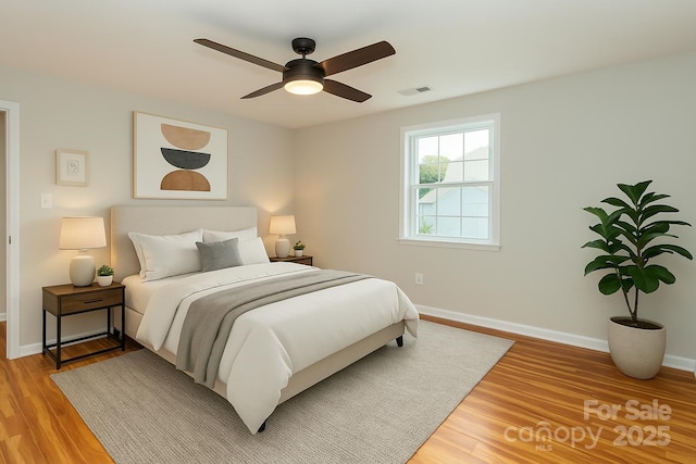 bedroom with light wood-style floors, baseboards, a ceiling fan, and visible vents