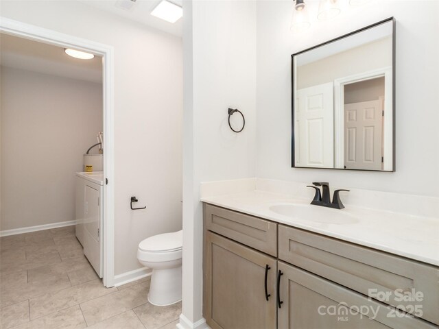 bathroom with baseboards, toilet, independent washer and dryer, vanity, and tile patterned flooring
