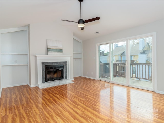 unfurnished living room with visible vents, ceiling fan, a fireplace, light wood-style flooring, and lofted ceiling