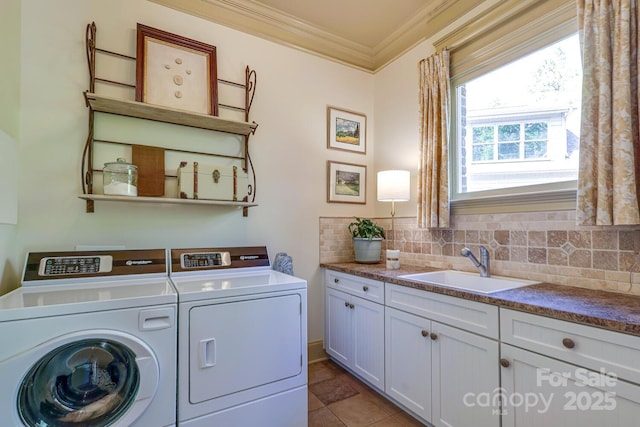 washroom featuring independent washer and dryer, crown molding, cabinet space, a sink, and light tile patterned floors